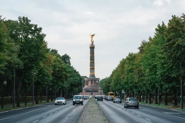 Berlin Straße mit Autos und einer Statue obenauf