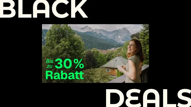 HENRI Hotels Black Deals Eine Frau steht auf einem Balkon mit Blick auf eine Bergkette.