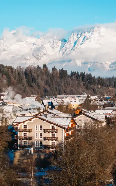 Ein Bergdorf mit schneebedeckten Bergen im Hintergrund.