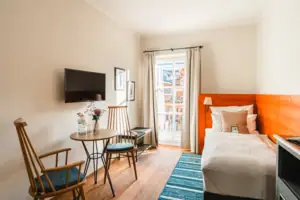 Zimmeransicht Ein Zimmer mit einem Bett, einem Tisch und Stühlen.