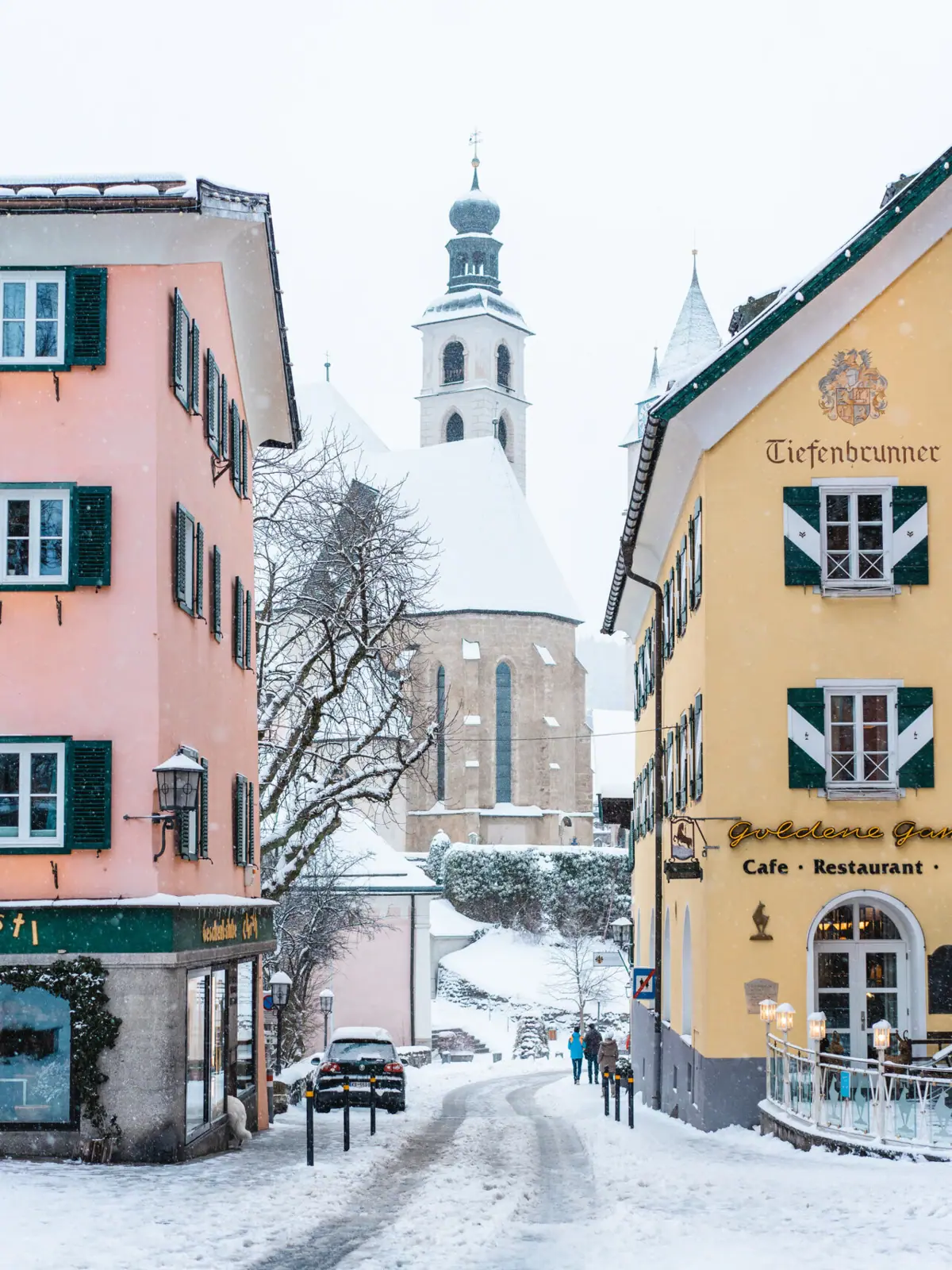 Altstadt Kitzbühel Eine Gruppe von Gebäuden mit Schnee auf dem Boden.