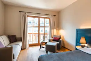 L-Studio Haus Ache HENRI Hotel Kitzbühel Ein Zimmer mit einem Fernseher und einem Sofa.