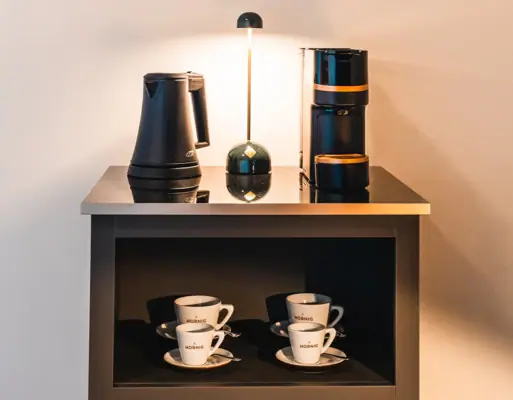 Kaffeemaschine Kaffeemaschine, Wasserkocher und Tassen auf einem Regal