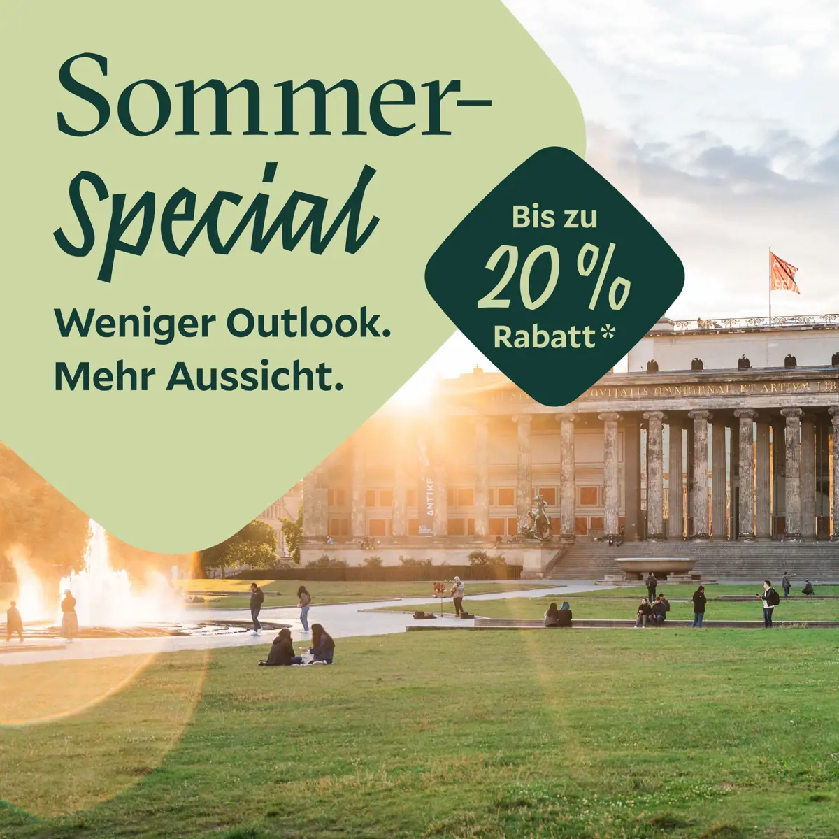 HENRI Sommer-Special Eine Gruppe von Menschen auf einer Wiese mit einem Brunnen vor einem Gebäude.