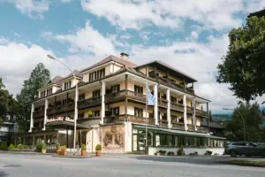 Außenansicht HENRI Hotel Garmisch-Partenkirchen Außenansicht HENRI Hotel Garmisch-Partenkirchen mit Bäumen und einer Straße.