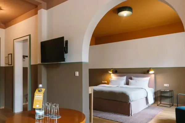 Hotelzimmer HERNI Garmisch-Partenkirchen Ein Zimmer mit einem Bett und einem Fernseher.