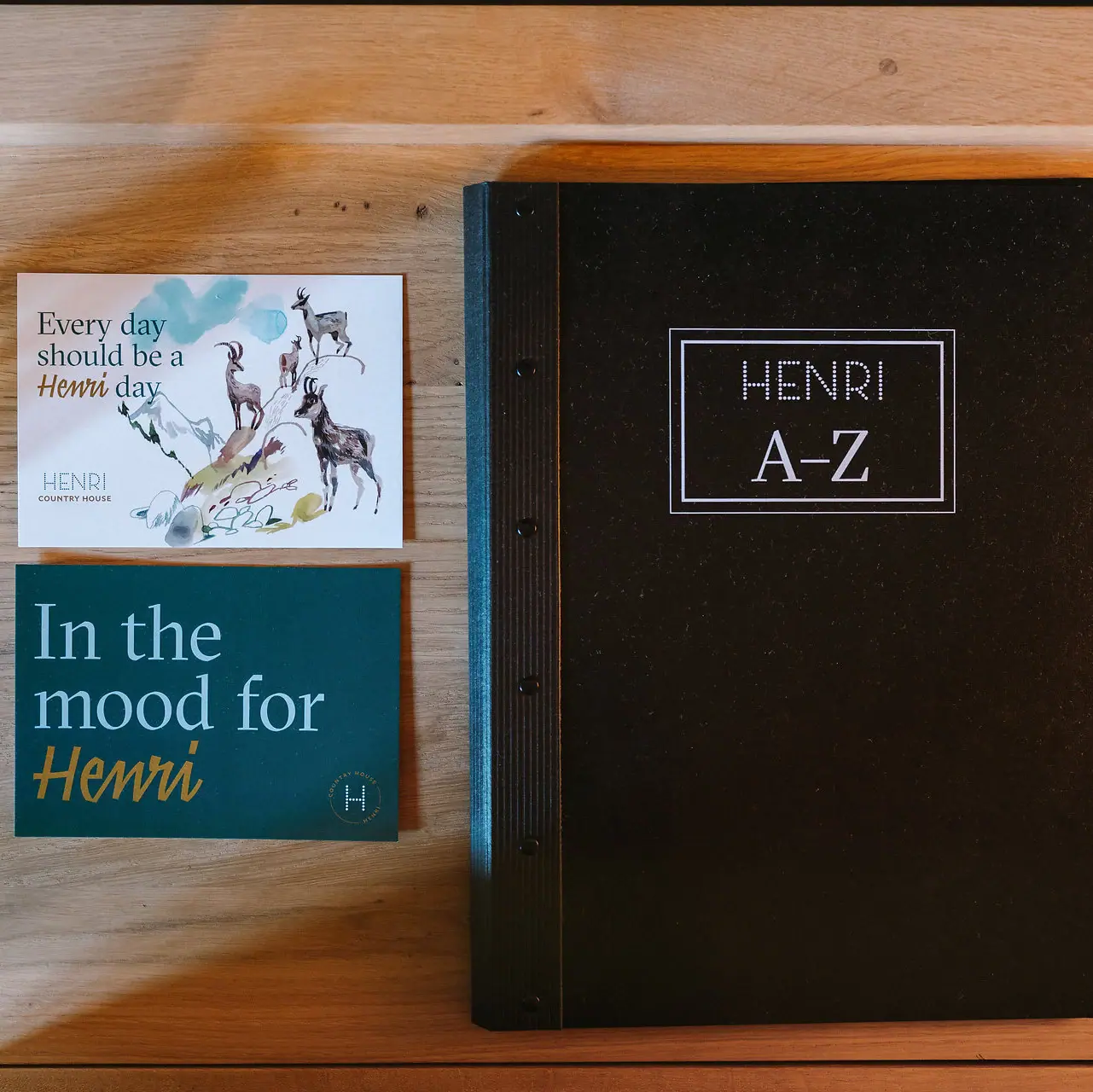 HENRI Zimmer-Details Ein Buch und eine Visitenkarte auf einem Tisch.