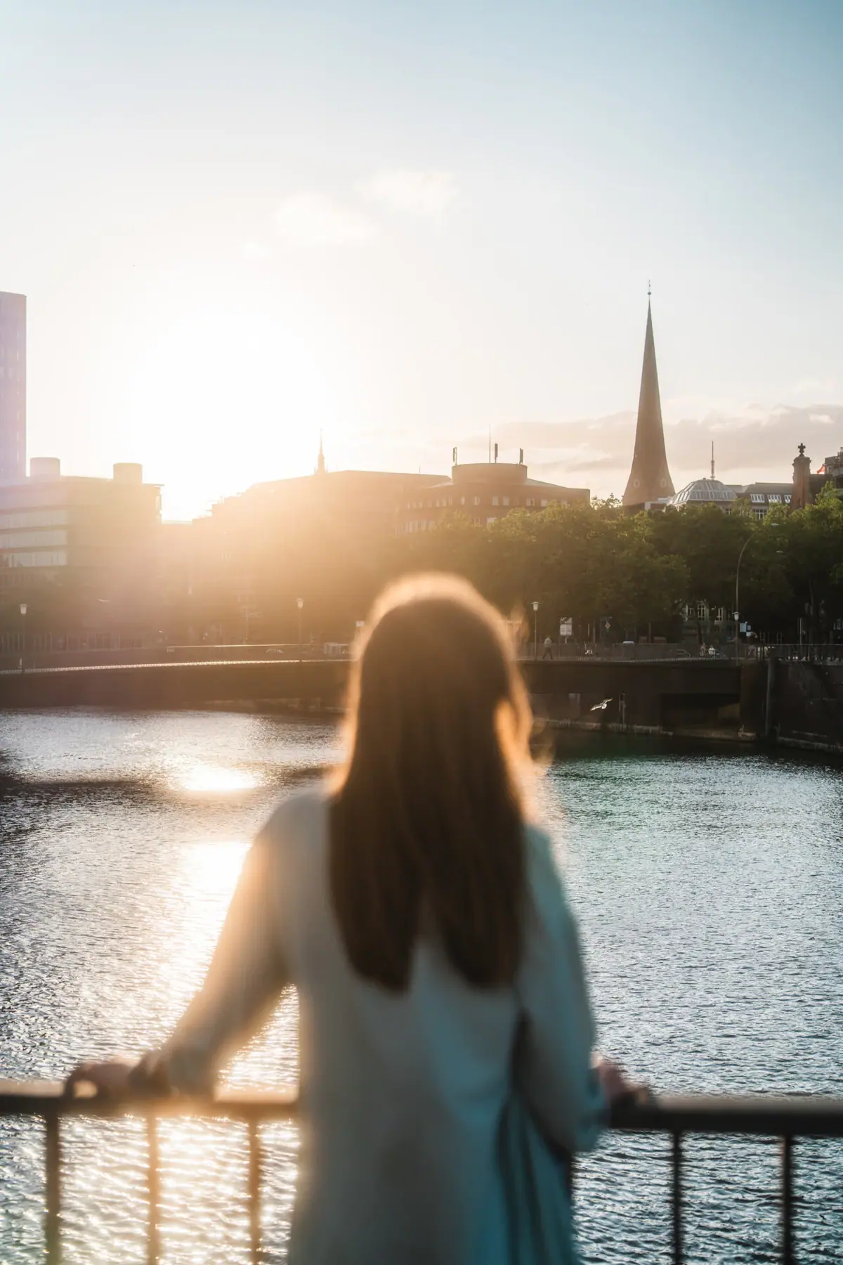 Hamburg Eine Frau steht auf einer Brücke und blickt auf eine Stadt.
