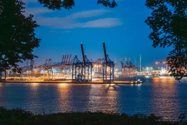Hamburg Großer Hafen mit Kränen und Lichtern bei Nacht.