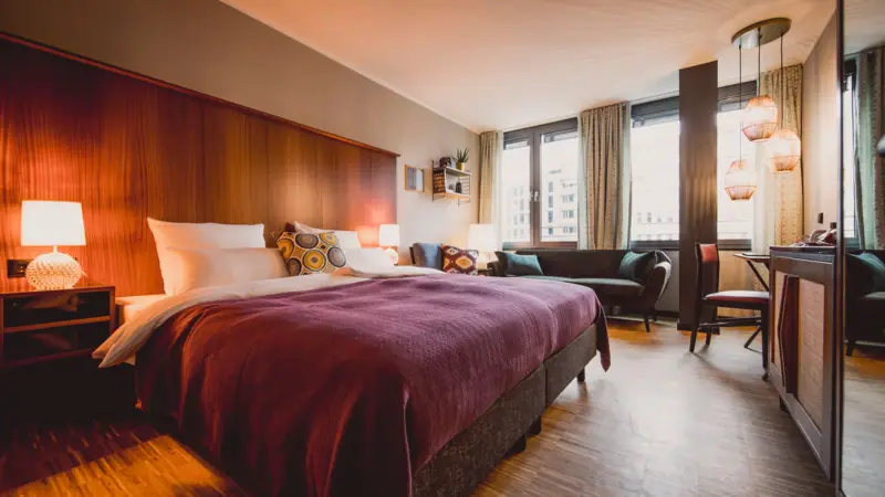 Zimmer & Studios im HENRI Düsseldorf Hotelzimmer mit Bett und Tisch.