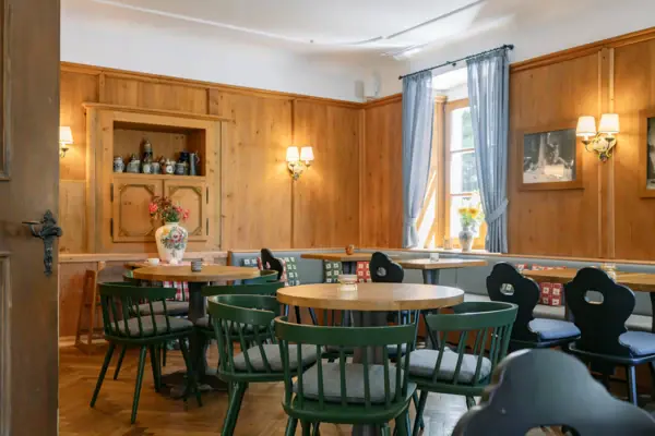 Klausner Stube im HENRI Hotel Kitzbühel Ein Raum mit Tischen und Stühlen.