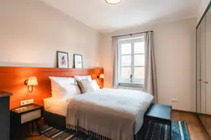 Bett Bett mit Holz-Kopfteil und Lampe im Schlafzimmer.