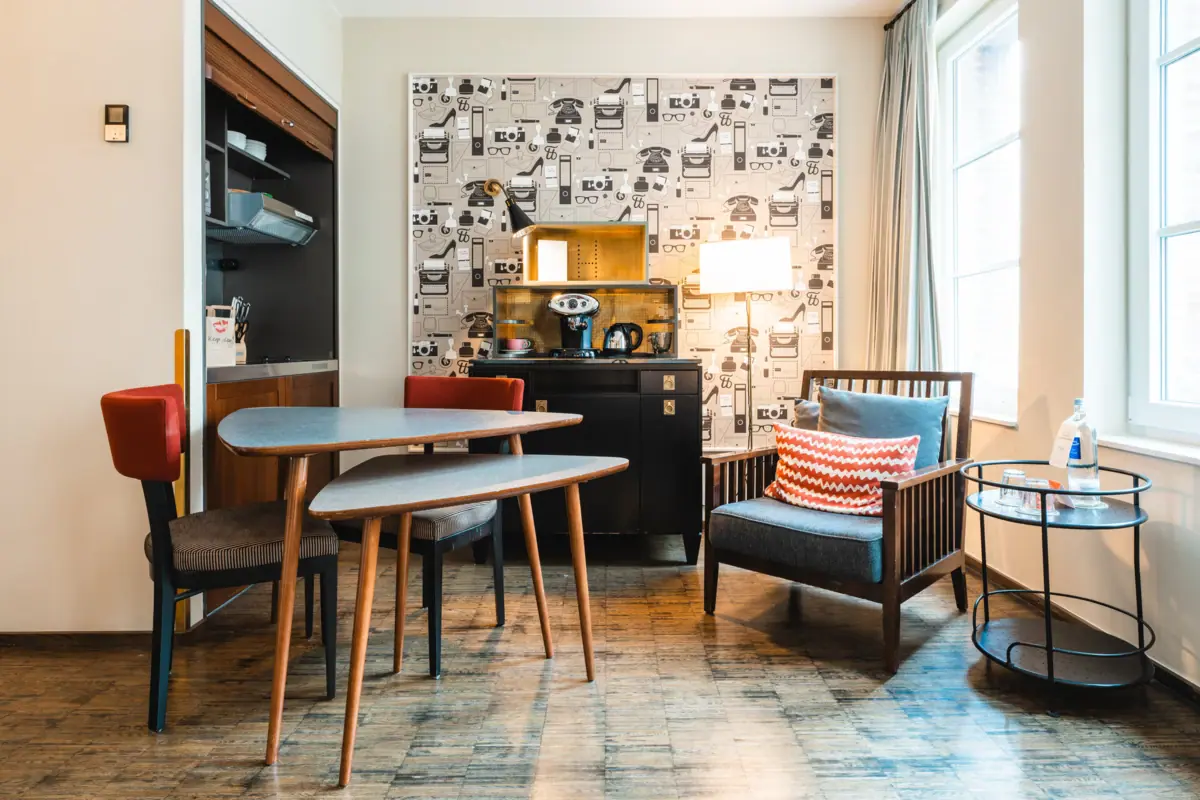 Esstisch und Sessel im Zimmer Ein Raum mit einem Tisch und Stühlen.