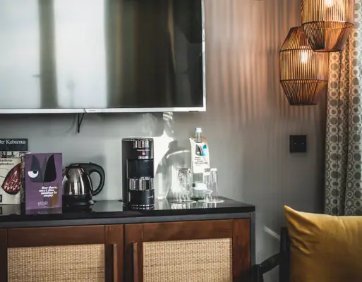 Tee- & Kaffeestation Ein Fernseher an einer Wand.