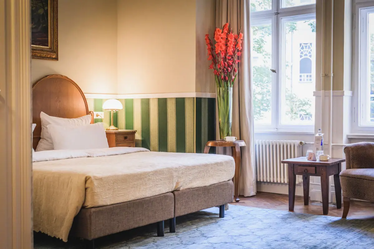 HENRI Berlin Salon Bogota Zimmer mit Bett und Blumenvase