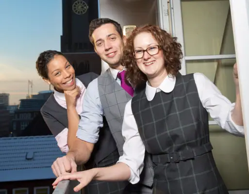 HENRI Mitarbeiter Eine Gruppe von Menschen steht vor einem Fenster.