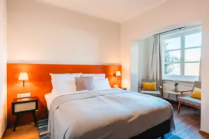 Bett Bett mit weißer Decke und orangenem Kopfteil