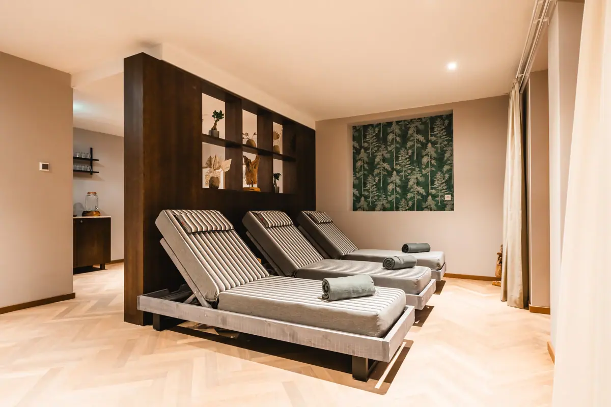 Ruheraum im HENRI Spa Ein Zimmer mit Stühlen und einer Wand.