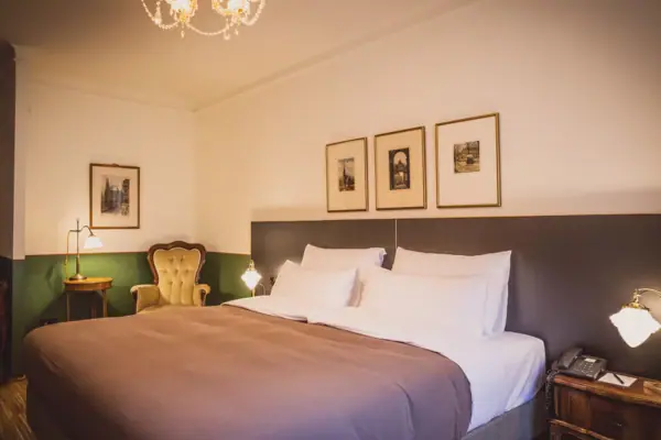 Zimmer Ein Bett mit einem Kronleuchter und Bildern an der Wand.