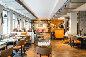 Loungebereich im HENRI Hotel Hamburg Loungebereich mit Tischen und Stühlen.