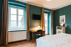 Zimmeransicht Ein Zimmer mit einem Bett und einem Schreibtisch.