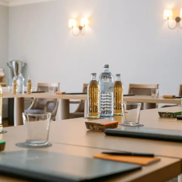 Eingedeckter Konferenztisch Ein Tisch mit Flaschen und Gläsern darauf.