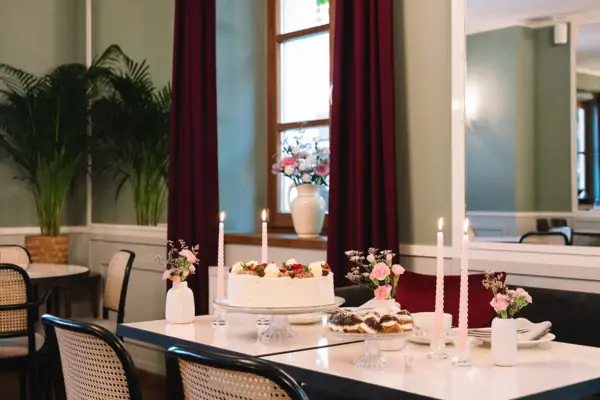 Spiegelsaal im HENRI Hotel Kitzbühel Ein Tisch mit einem Kuchen und Kerzen.