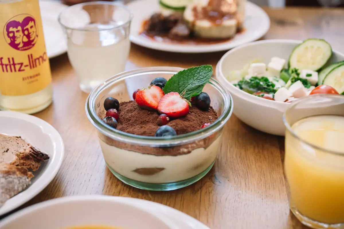 Dessert Schale mit Dessert, garniert mit Erdbeeren und Blaubeeren.