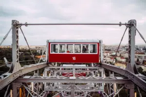 Prater Rotes und weißes Riesenrad vor bewölktem Himmel.