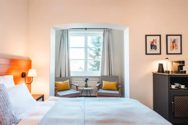 Bett mit Ausblick Ein Schlafzimmer mit einem Bett und Stühlen.