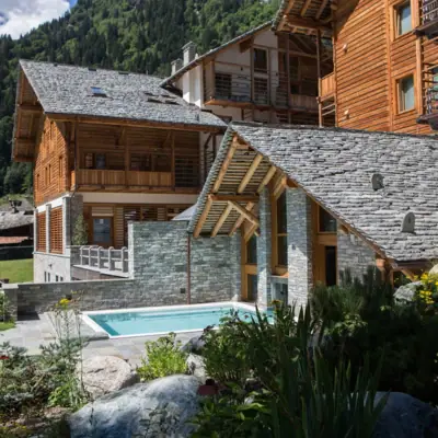 Mira Hotel Außenansicht Ein Hotel mit Pool im Vordergrund und Bergen im Hintergrund.