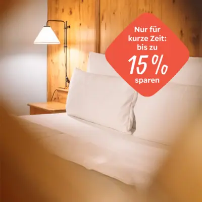 Herbst-Special Bett mit weißen Laken und einer Lampe