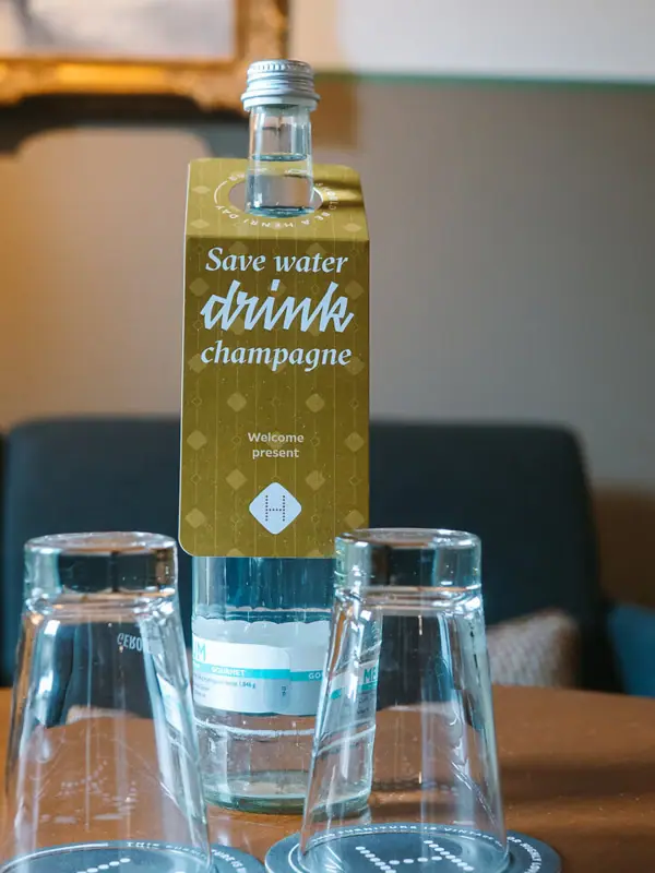 Wasserflasche Hotelzimmer Flasche Wasser mit zwei Gläsern auf einem Tisch.