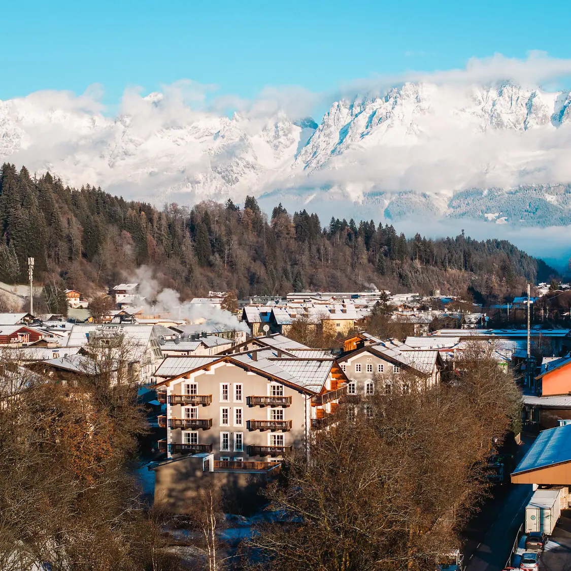 HENRI Kitzbühel mit verschneiten Bergen Bergdorf mit schneebedeckten Bergen im Hintergrund.