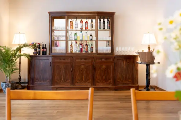 Ache Galerie 2 im HENRI Hotel Kitzbühel Eine Hausbar mit Gläsern und Flaschen darauf.