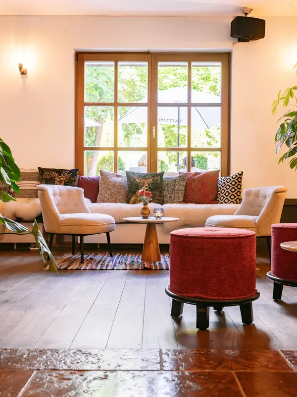 Gemütliche Sitzgruppe im HENRI Kitzbühel Wohnzimmer mit Sofas und Sesseln.