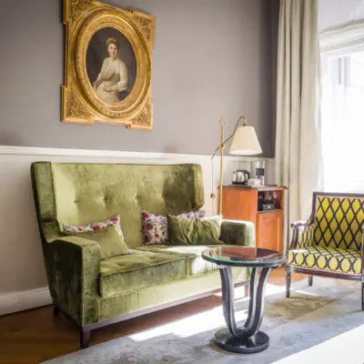 HENRI Berlin Salon Zimmer Wohnzimmer mit Couch und Couchtisch.