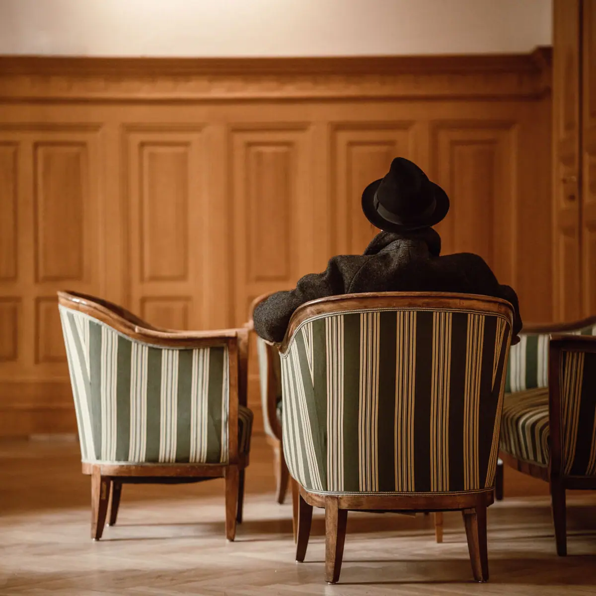 HENRI in Wien Ein Mann sitzt auf einem Stuhl.