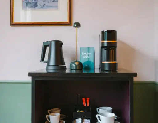 Zimmerbar HENRI Hotel Garmisch-Partenkirchen Eine Zimmerbar in einem Hotelzimmer des HENRI Hotels in Garmisch-Partenkirchen mit einer Kaffee- und Teestation.