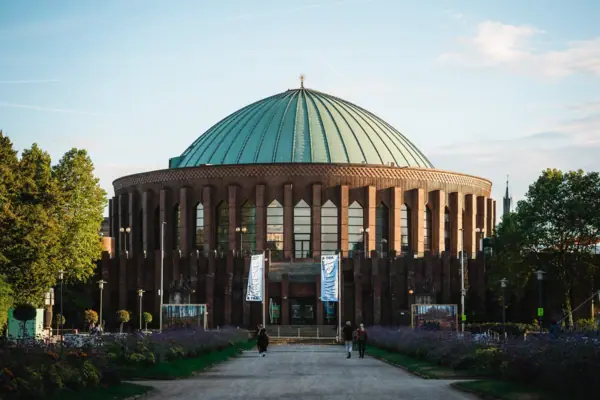Tonhalle Düsseldorf Ein Gebäude mit Kuppel und Menschen, die davor spazieren.
