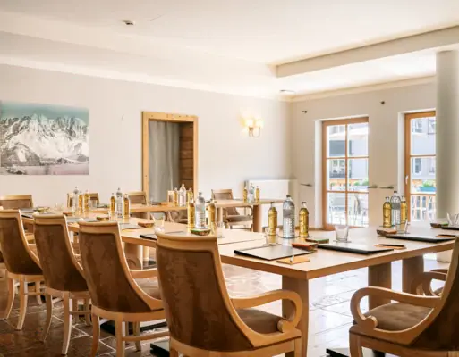 Tagungsraum im HENRI Hotel Kitzbühel Ein Raum mit Tischen und Stühlen.