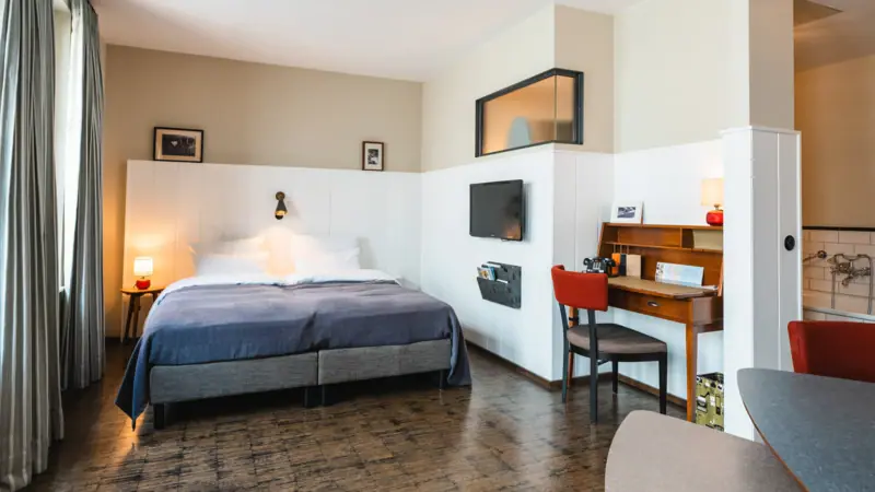 Zimmer im HENRI Hotel Hamburg Zimmer mit Bett und Schreibtisch iim HENRI Hotel Hamburg.