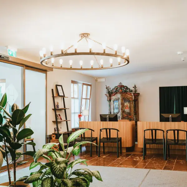 Rezeption Ein Zimmer mit einem Kronleuchter und Stühlen.